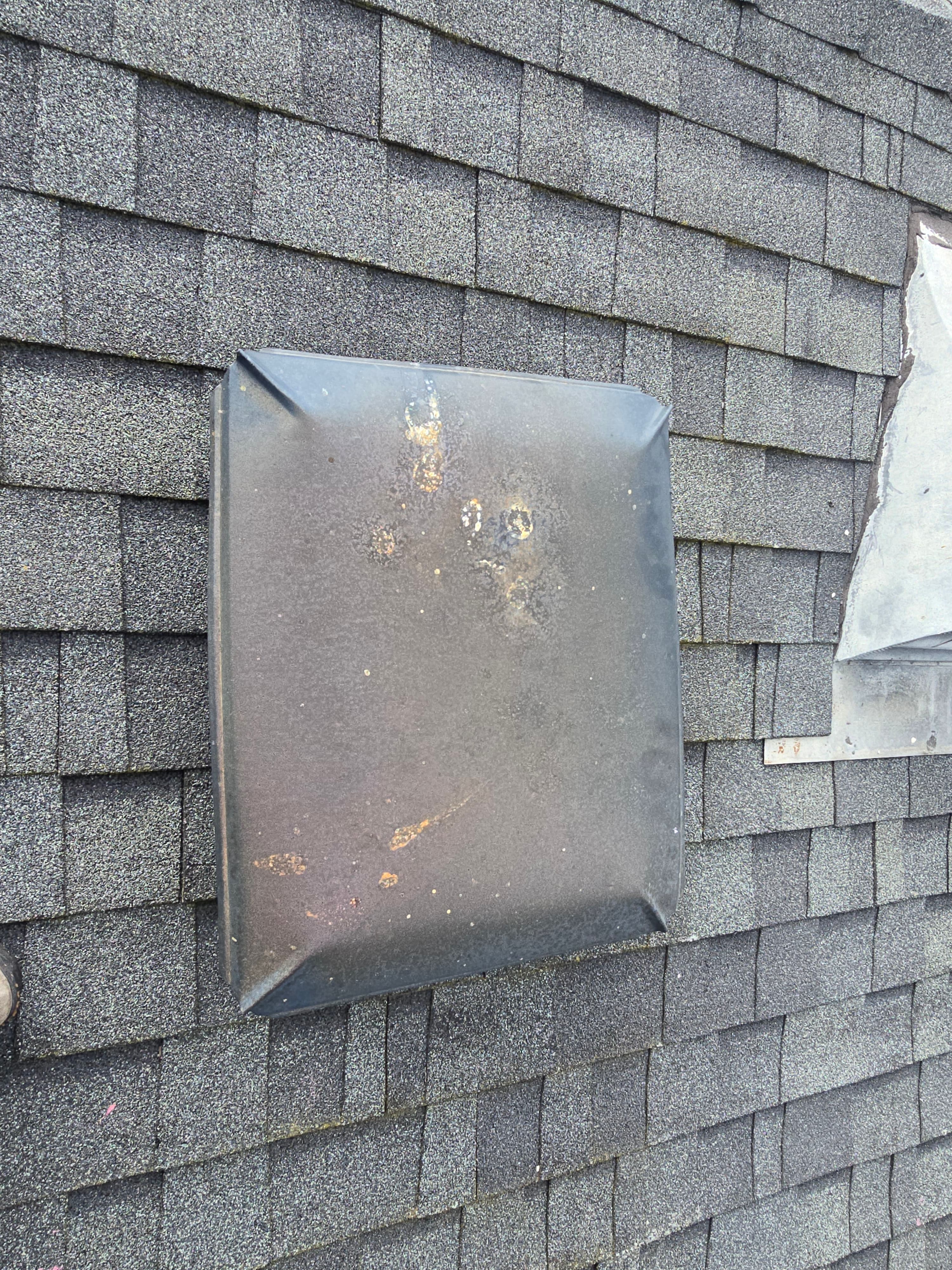 Rusted galvanized chimney cap with visible corrosion
