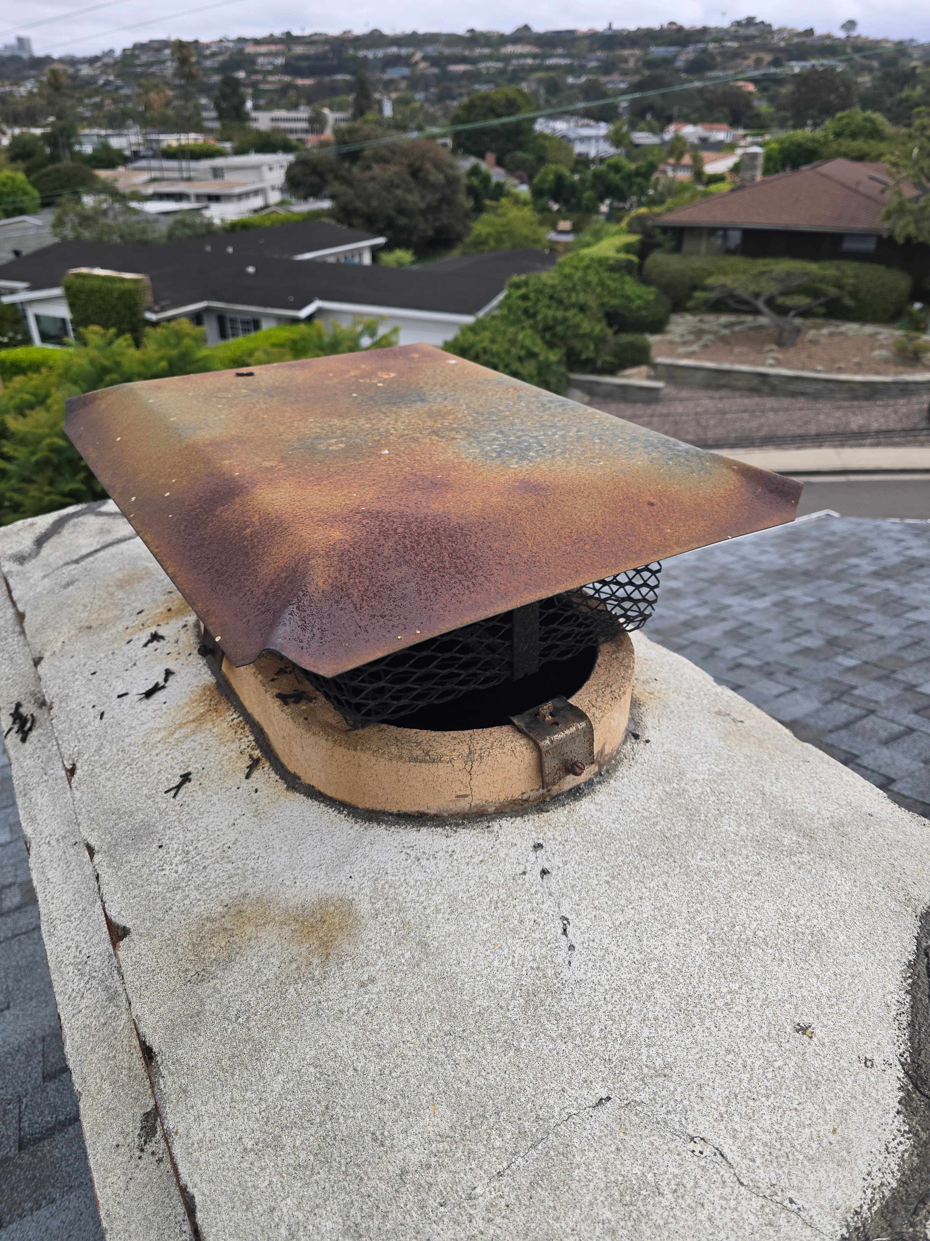 Old screw-in chimney cap attached near a masonry flue tile