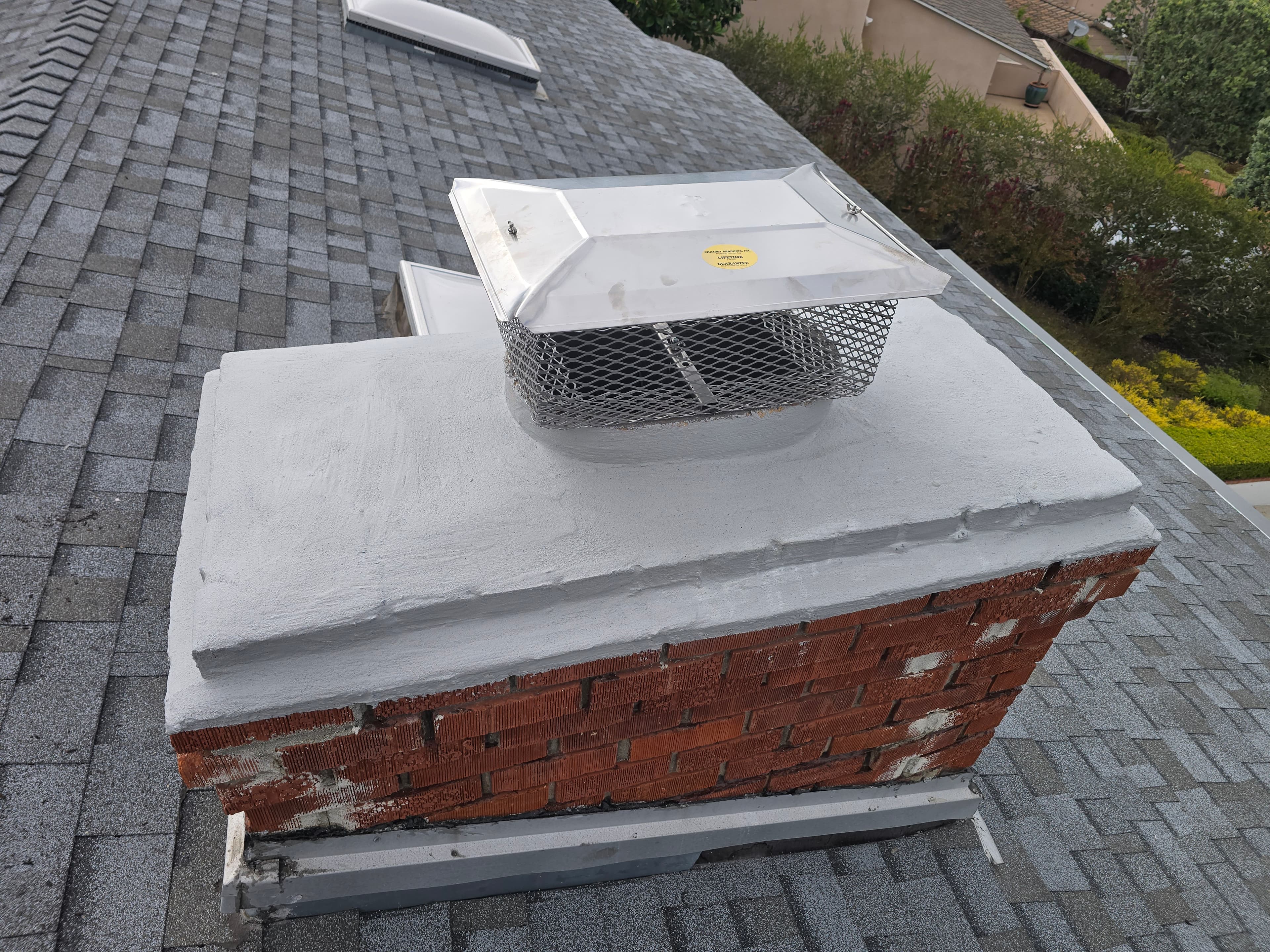 Stainless steel chimney cap installed over a masonry flue