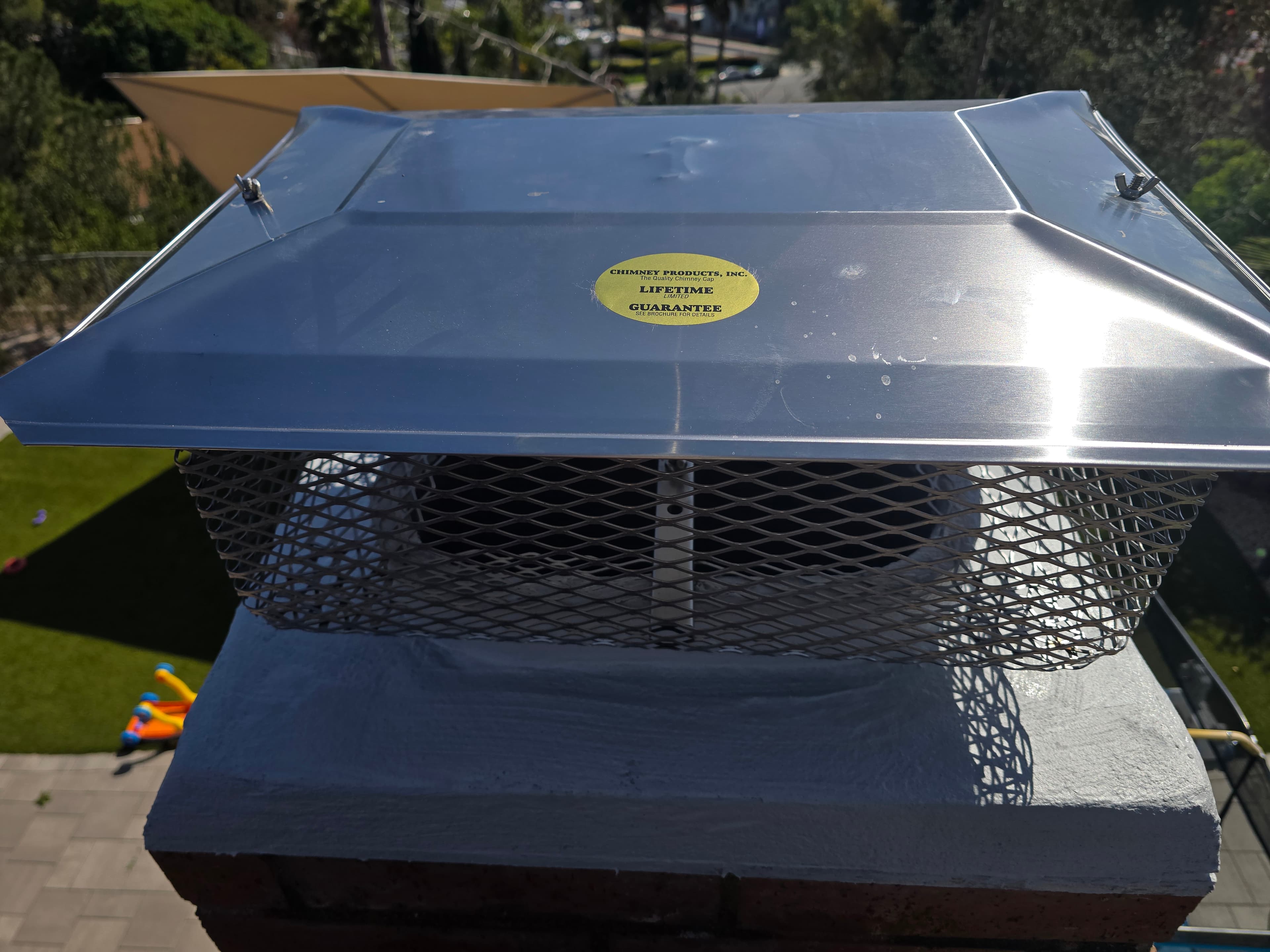 Close view of a stainless steel chimney cap with mesh sides