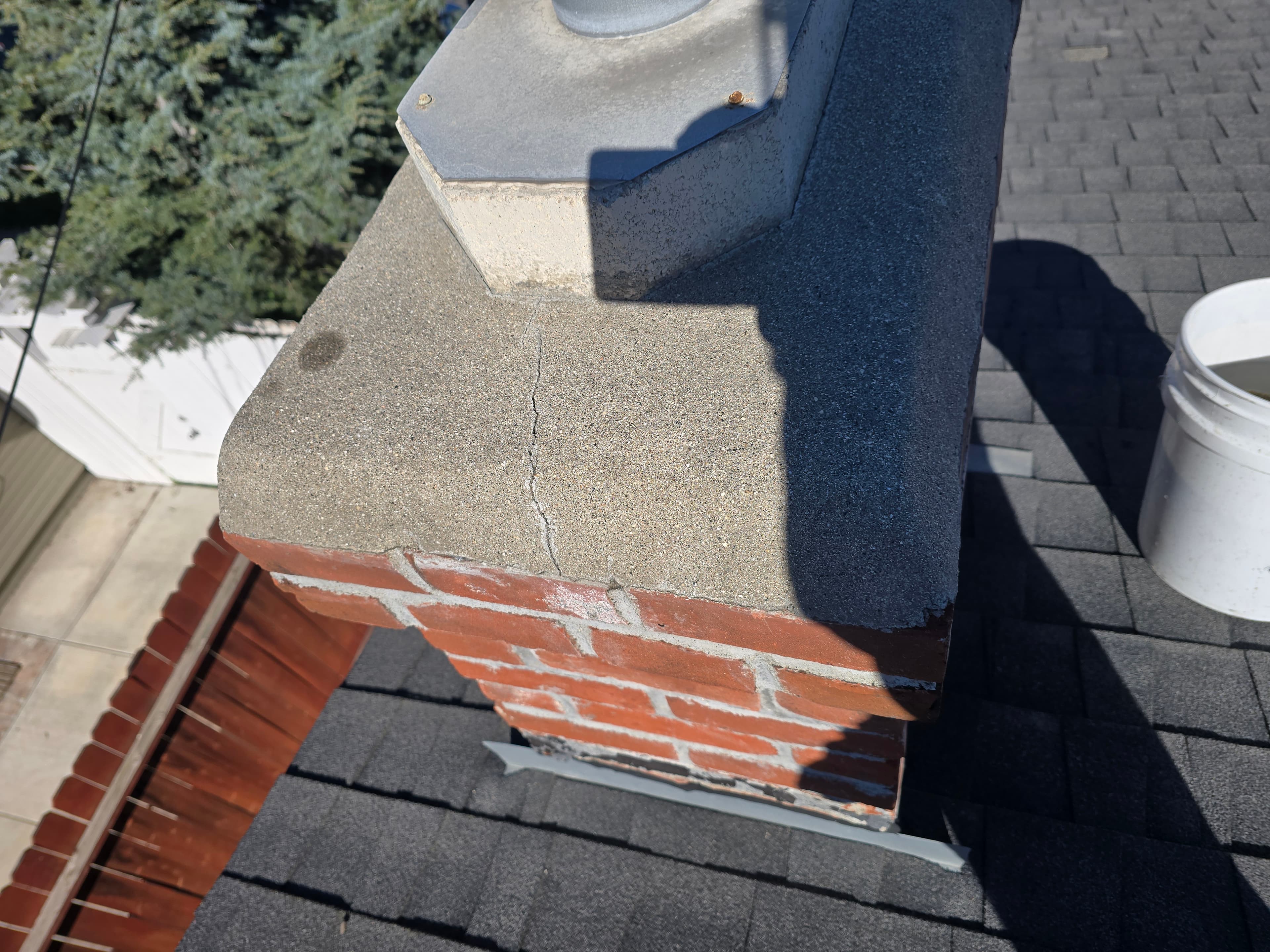 Damaged chimney crown with visible cracking